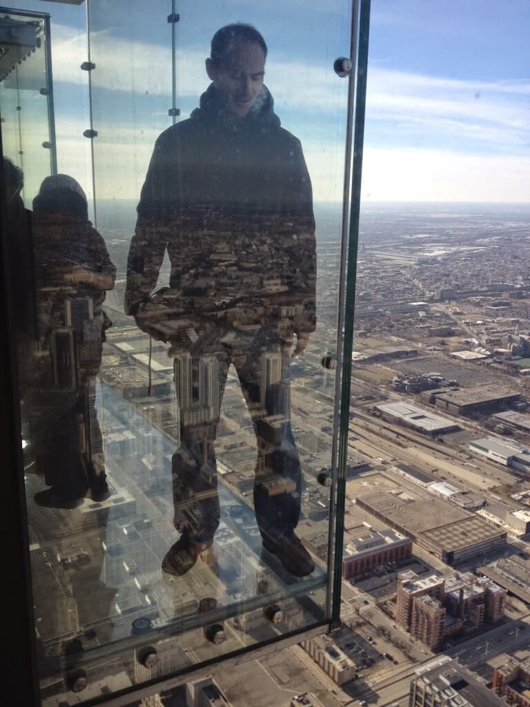 Tall Guy standing on ledge at the skydeck of Willis Tower